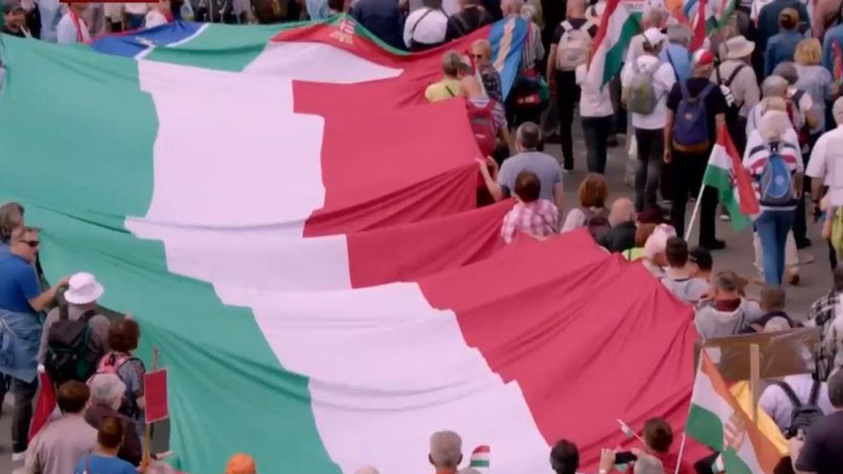 A Himnuszt éneklő tömeg hatalmas zászlókkal vonul a Békemenetben – Ünnepélyes pillanatok az utcákon